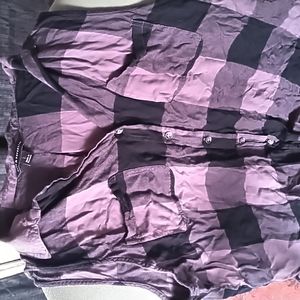 Plaid, sleeveless button up that is pleated in back